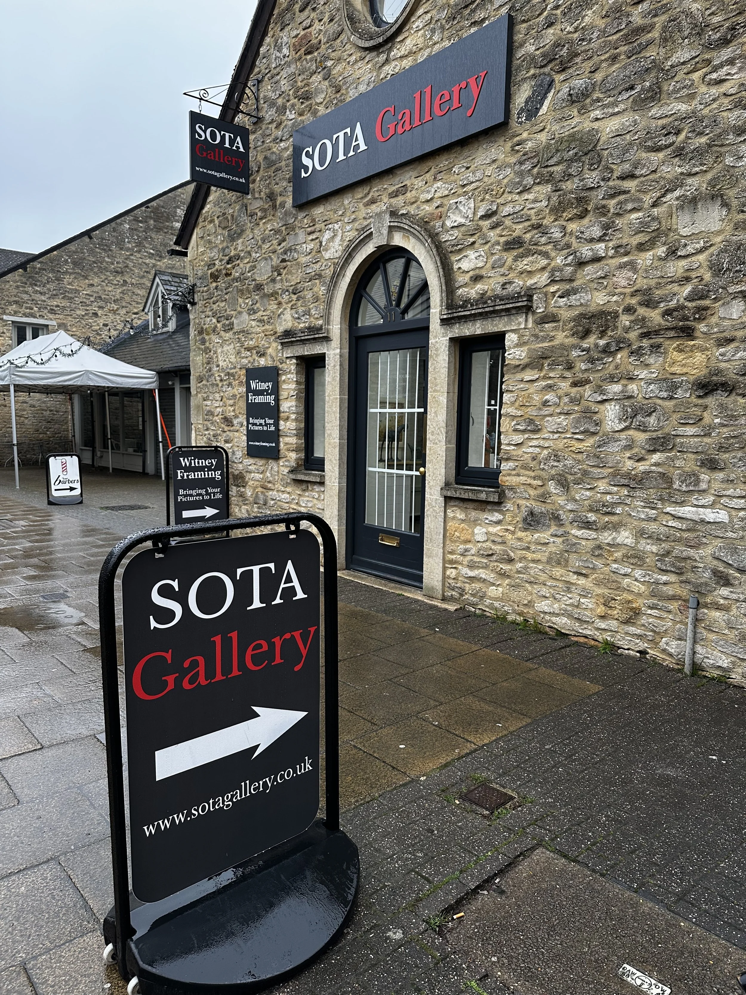 The front of the SOTA Gallery building, a traditional stone building with SOTA signs.