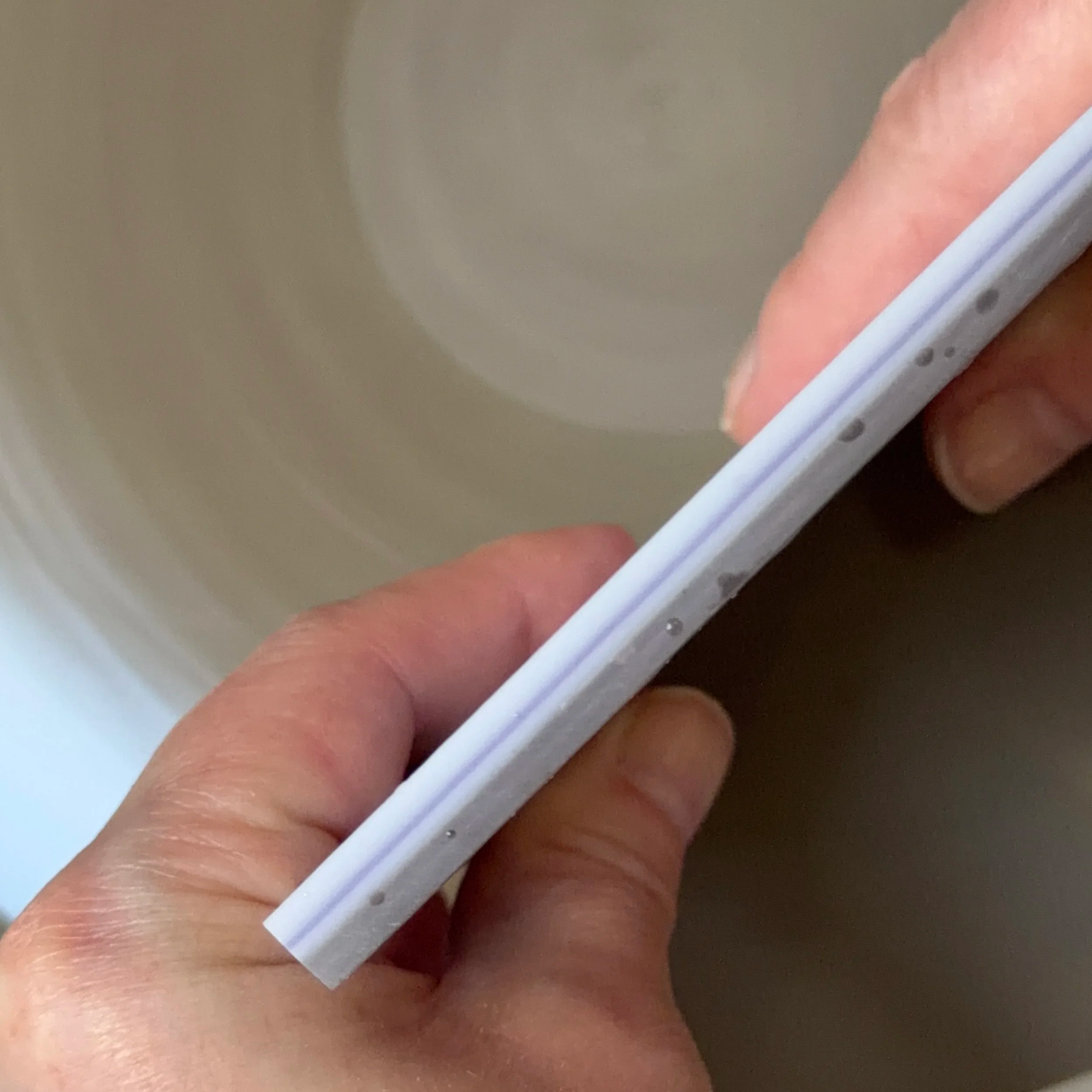 Showing a close up of a larger glass piece on a grinding wheel.