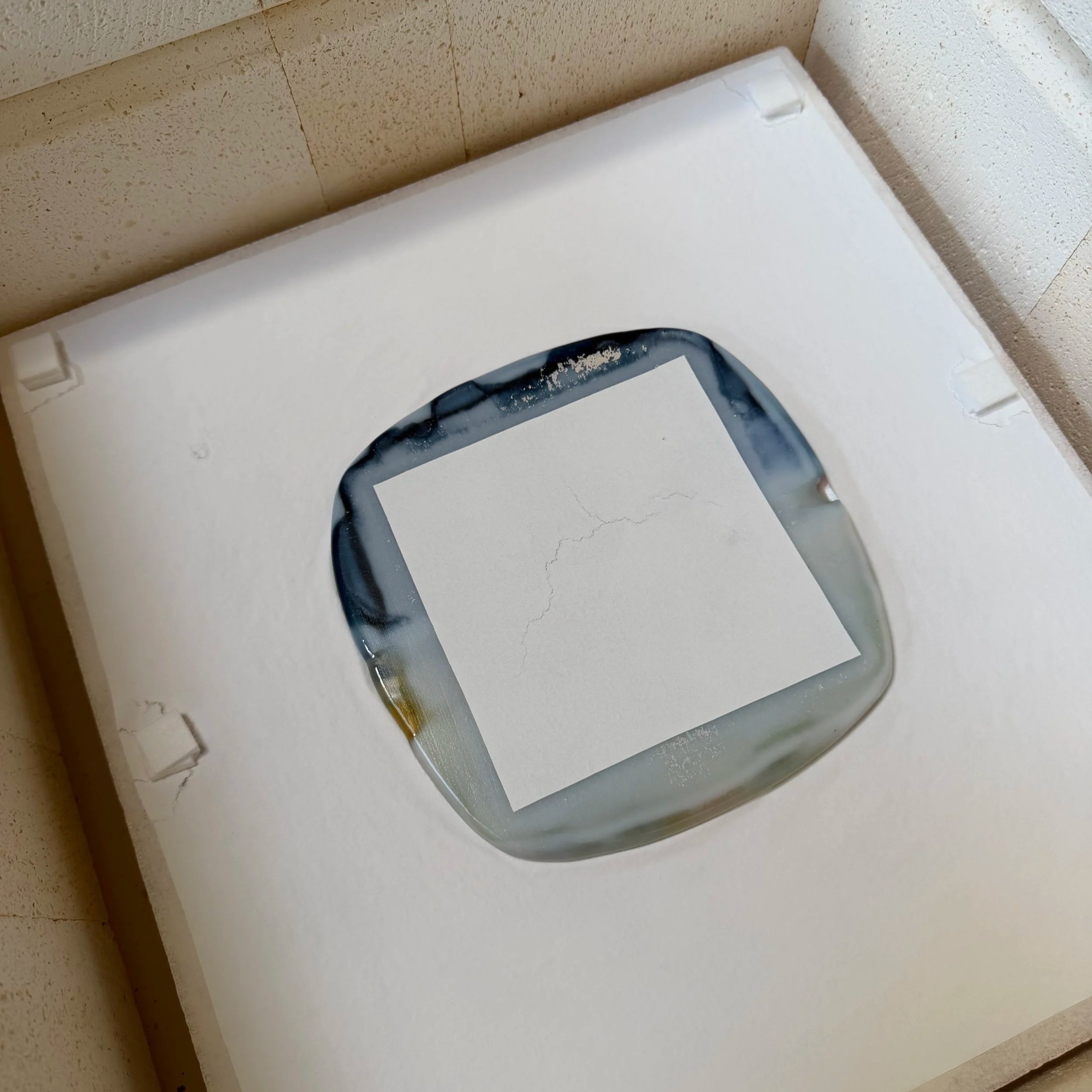 After firing the glass shows a square piece compressed on a kiln shelf.
