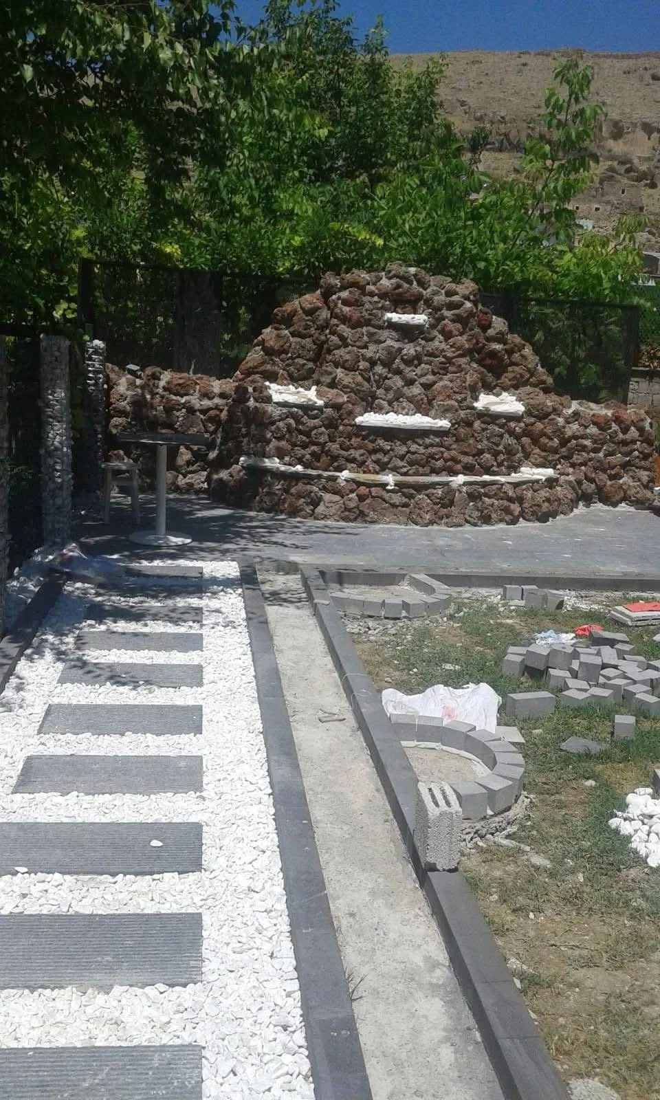 Stone fountain complemented by a walkway featuring pavers and crushed stone