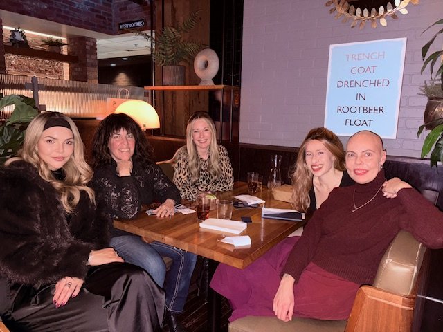 a group of women in a restaurant smiling at the camera