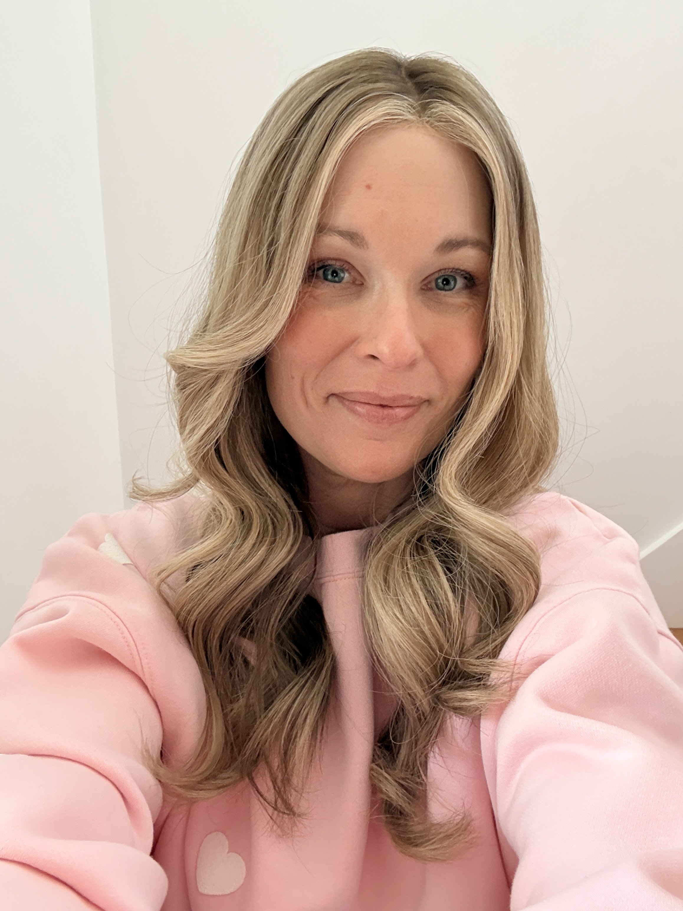 white woman with long blonde hair and blue eyes smiling at the camera