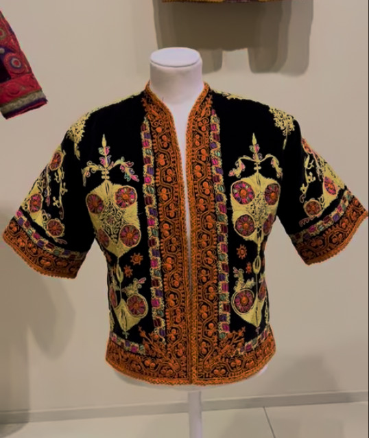 Black velvet Palestinian jacket decorated with colourful Tahriri couching embroidery and floral motifs