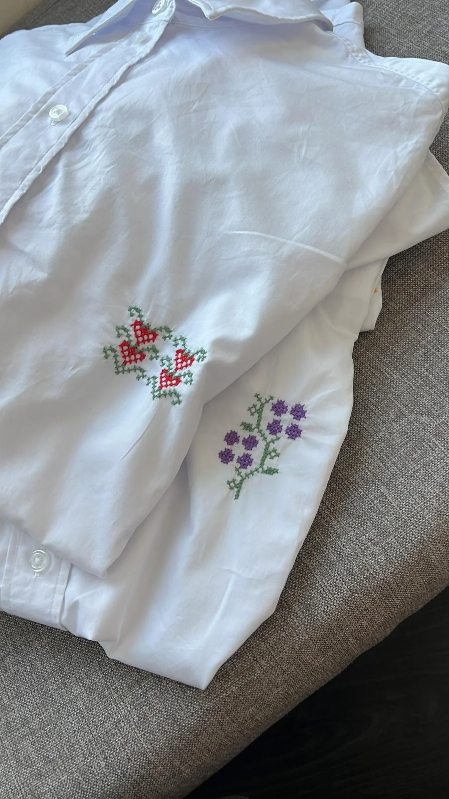 White shirt customised with burgundy Palestinian tatreez embroidery on the cuffs for a wedding in Sweden.