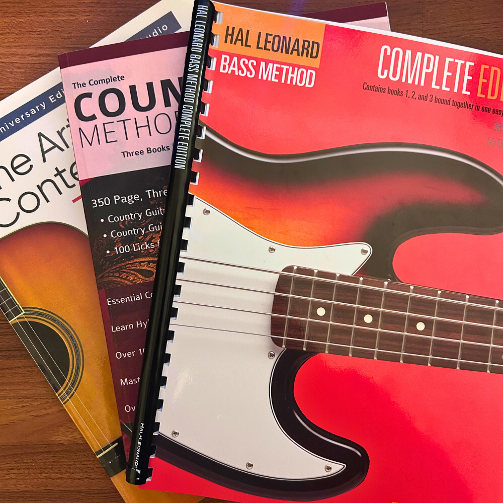 Several lesson books from Zac Watsons musical resource collection sit in a pile.