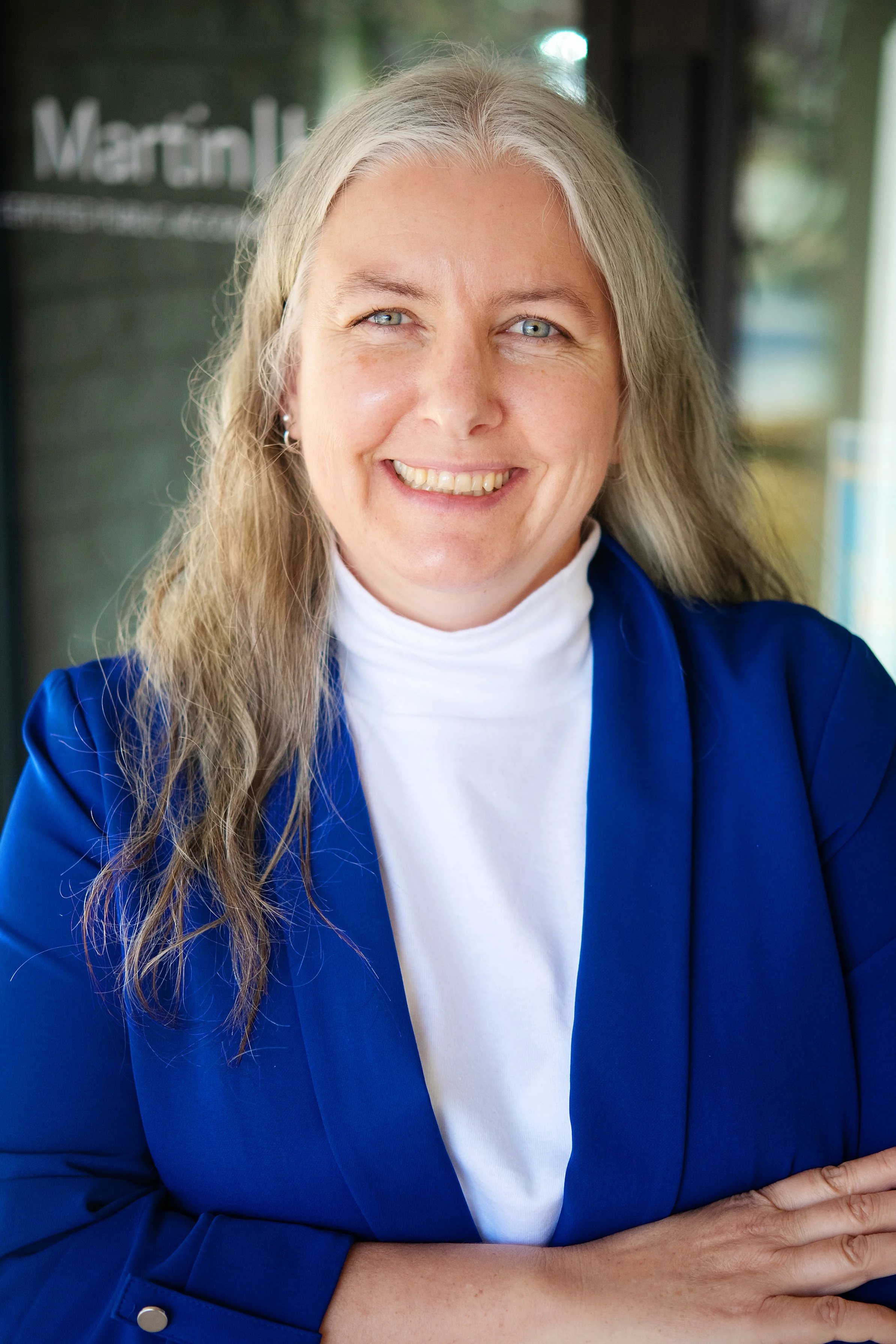 woman in blue blazer and white shirt. Employee photo.