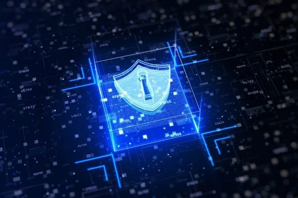 A digital shield icon surrounded by cybersecurity network connections and data visualisations, representing layered security defence systems for businesses