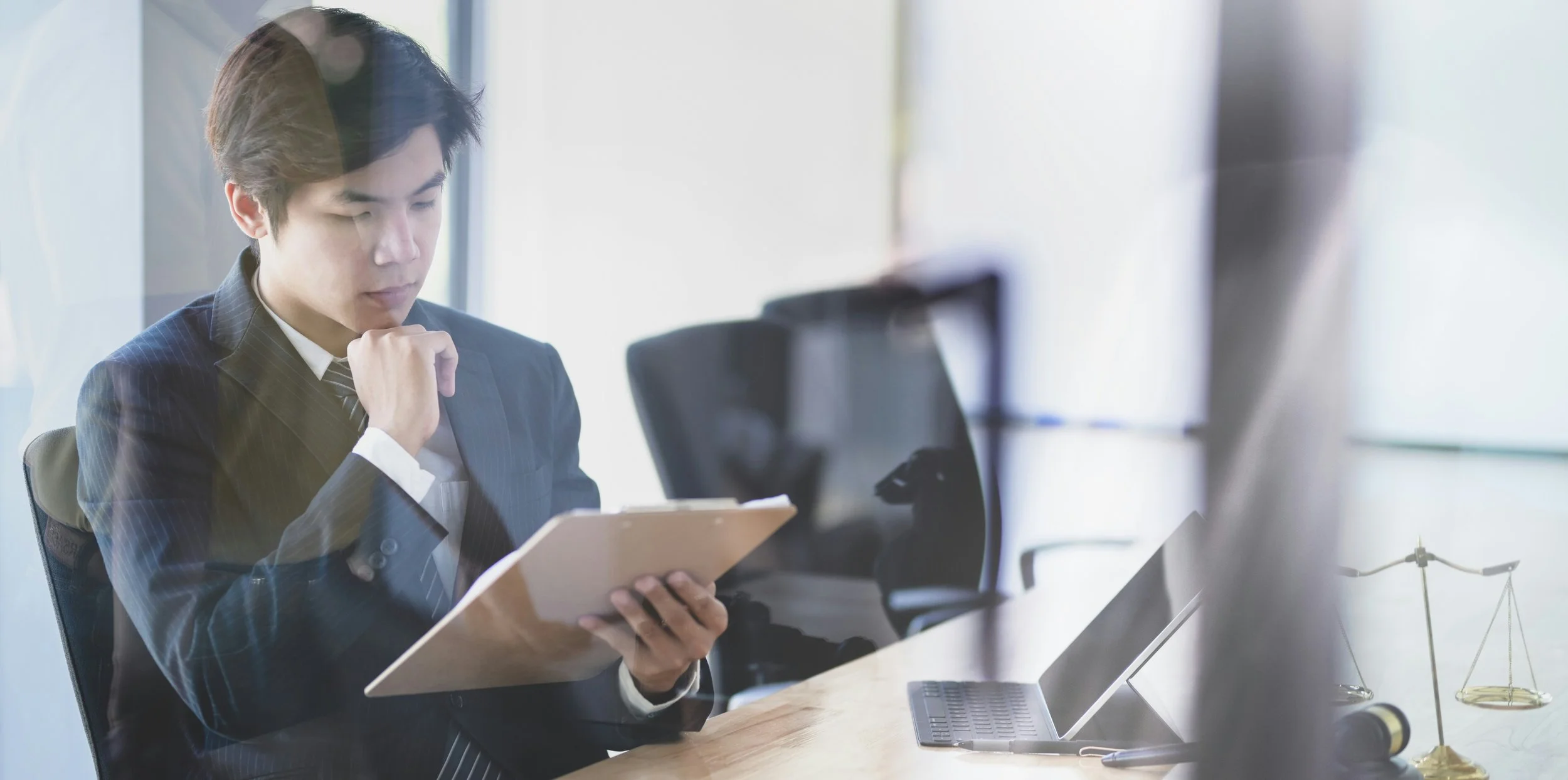 A solicitor working at a desk reviewing emails on a laptop, representing the everyday scenario where email fraud occurs in UK law firms