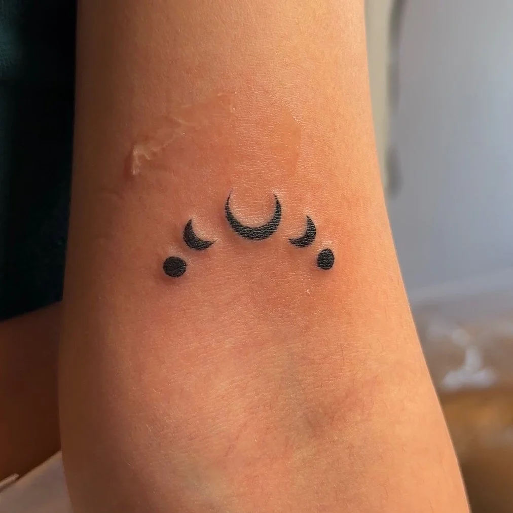 Fine line tattoo of moon phases on skin in Los Angeles