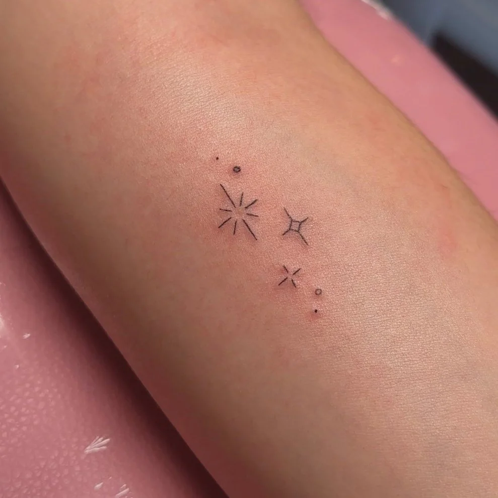 Minimalist star tattoo on skin with various small star and dot designs done in in Los Angeles