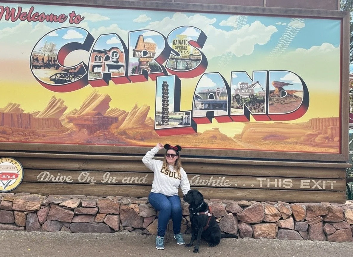 Lindsay and Eve in front of the California Adventure Cars Land sign.