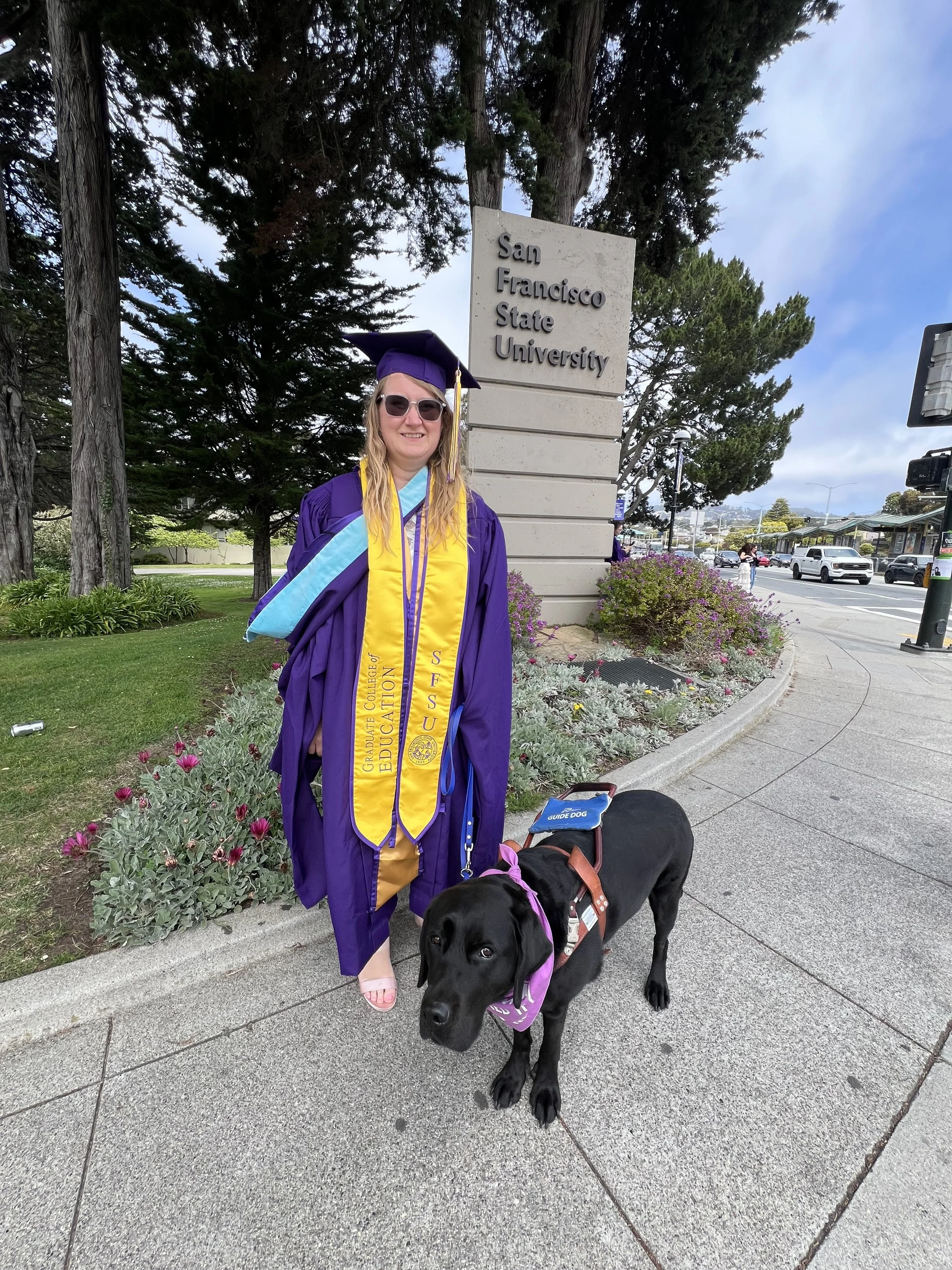 Lindsay and Eve standing together with the San Francisco State sign just behind them