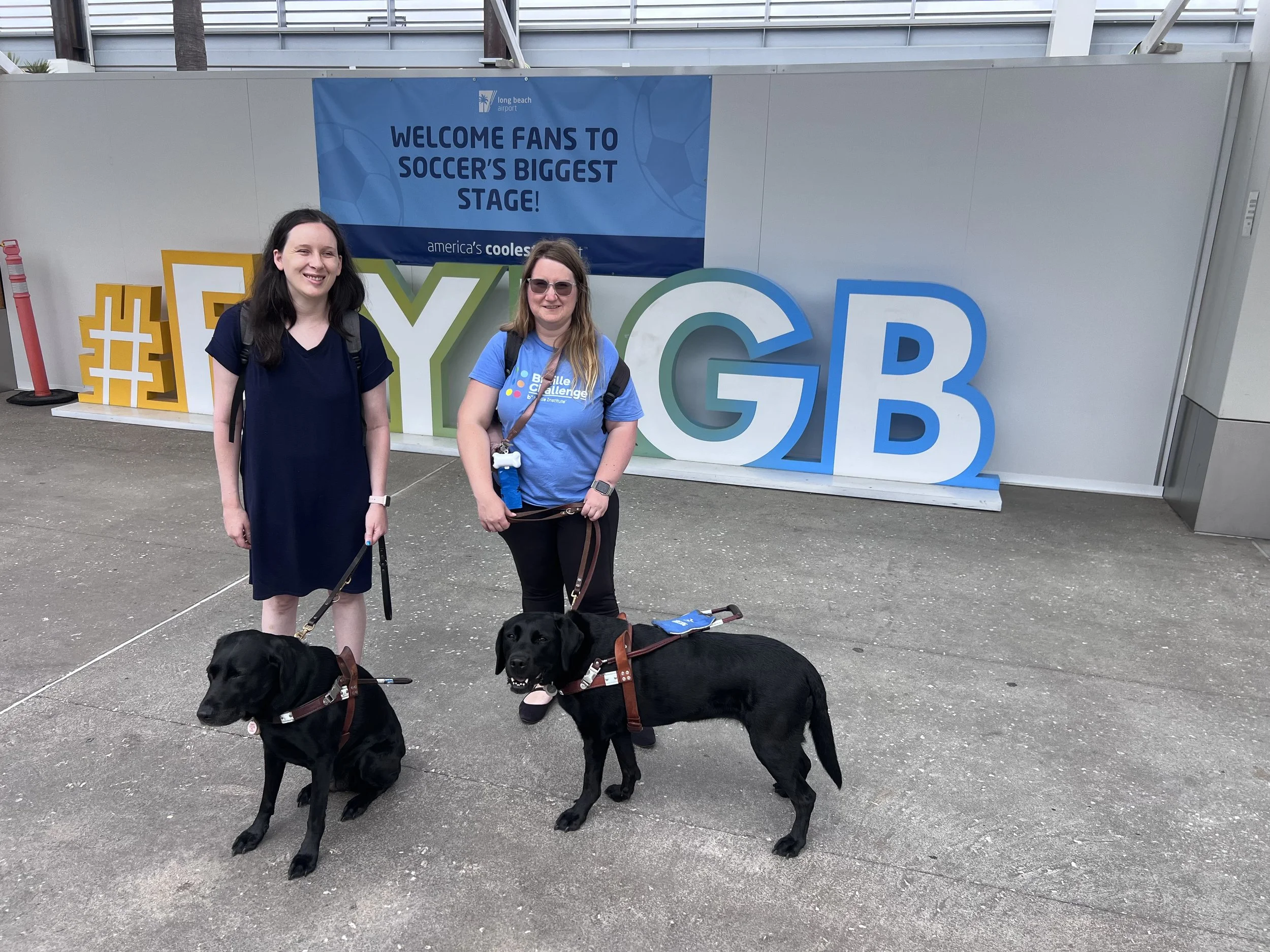 Shelbi, Kristen, Lindsay, and Eve in front of the #FlyLGB Sign at the Long Beach airport before heading to Austin.