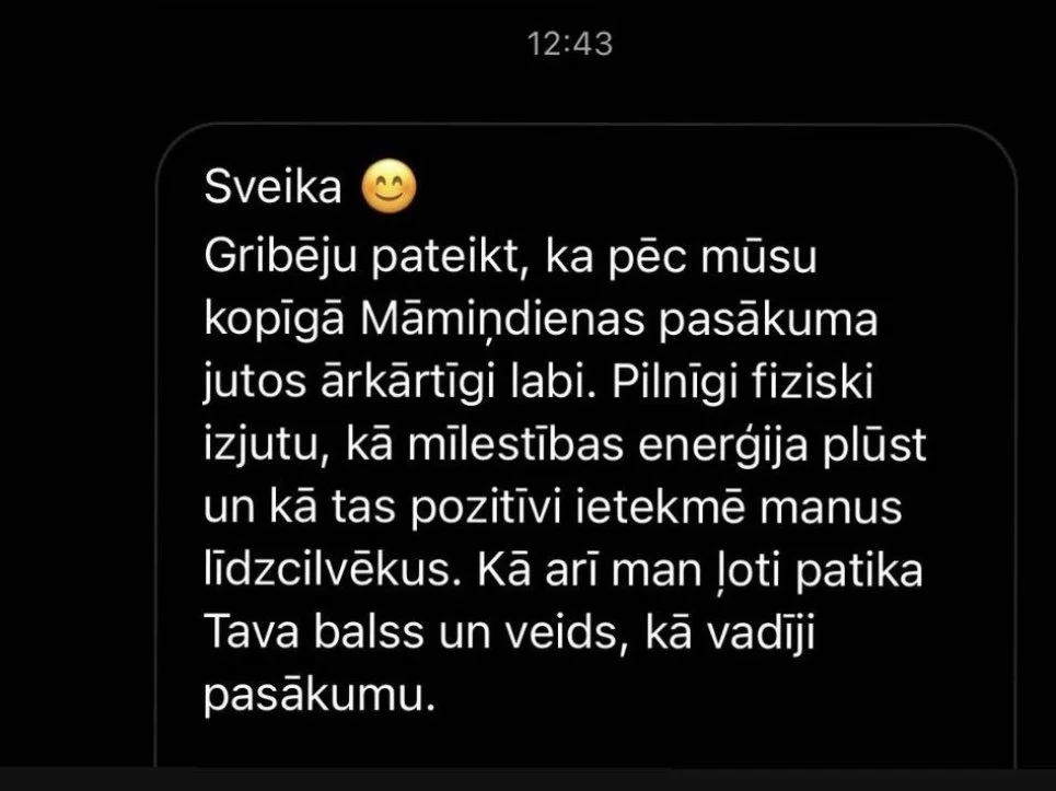 Smartphone screen displaying a Latvian text message with positive feedback about a Mother's Day event.