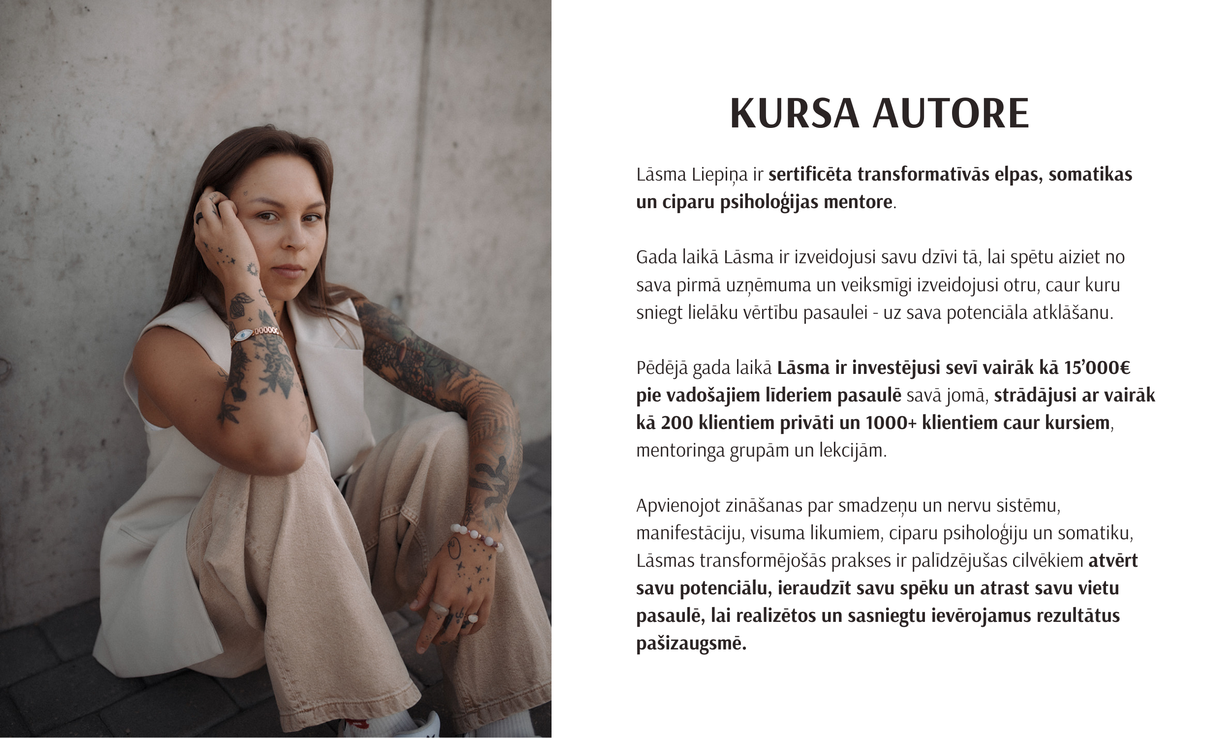 A woman with tattoos on her arms and fingers, wearing a white sleeveless top and beige pants, sitting against a concrete wall, looking at the camera with a serious expression.