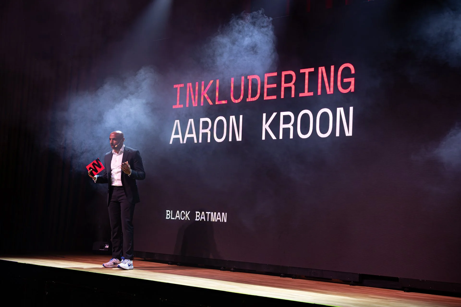 Aaron Kroon står på en scen under en föreläsning.