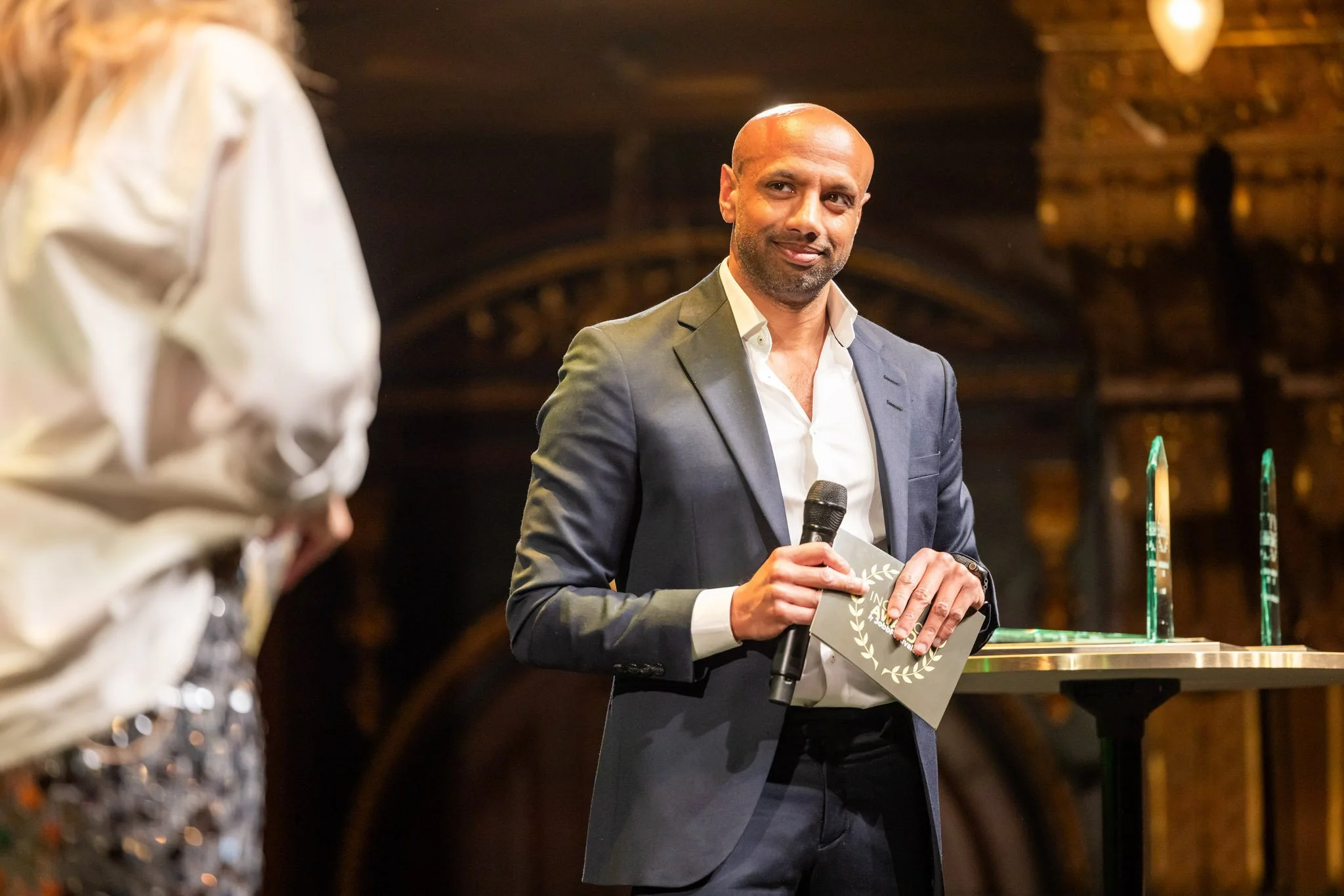 Aaron Kroon står på en scen under en föreläsning.