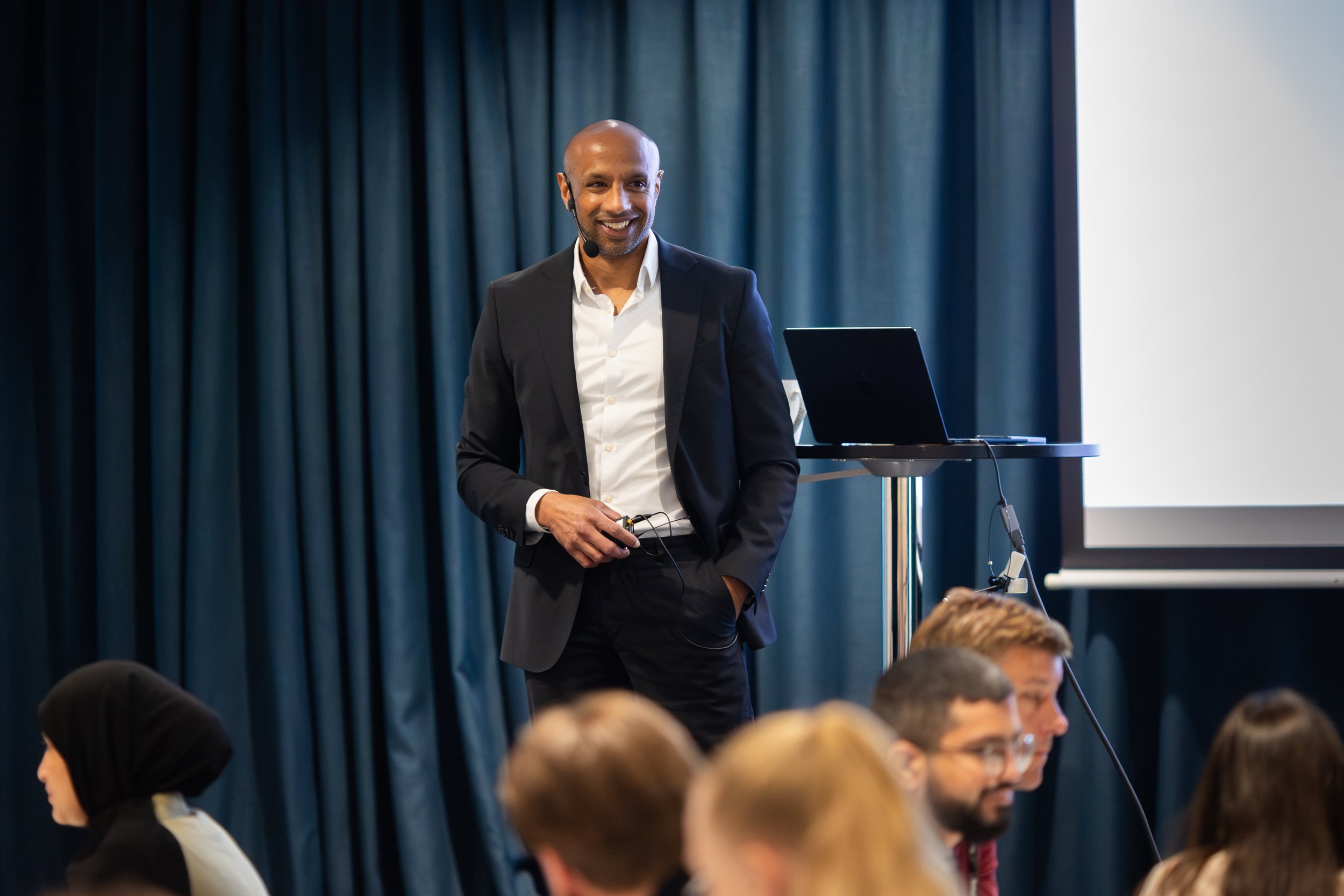 Aaron Kroon står på en scen under en föreläsning.