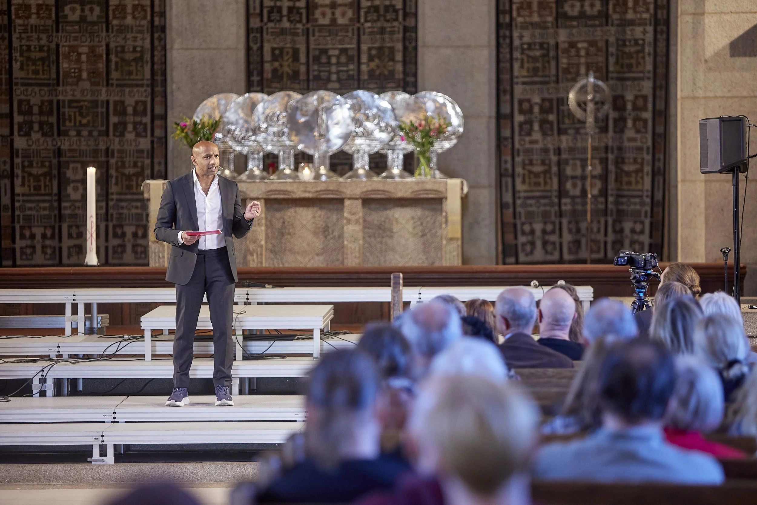 Aaron Kroon står på en scen under en föreläsning.