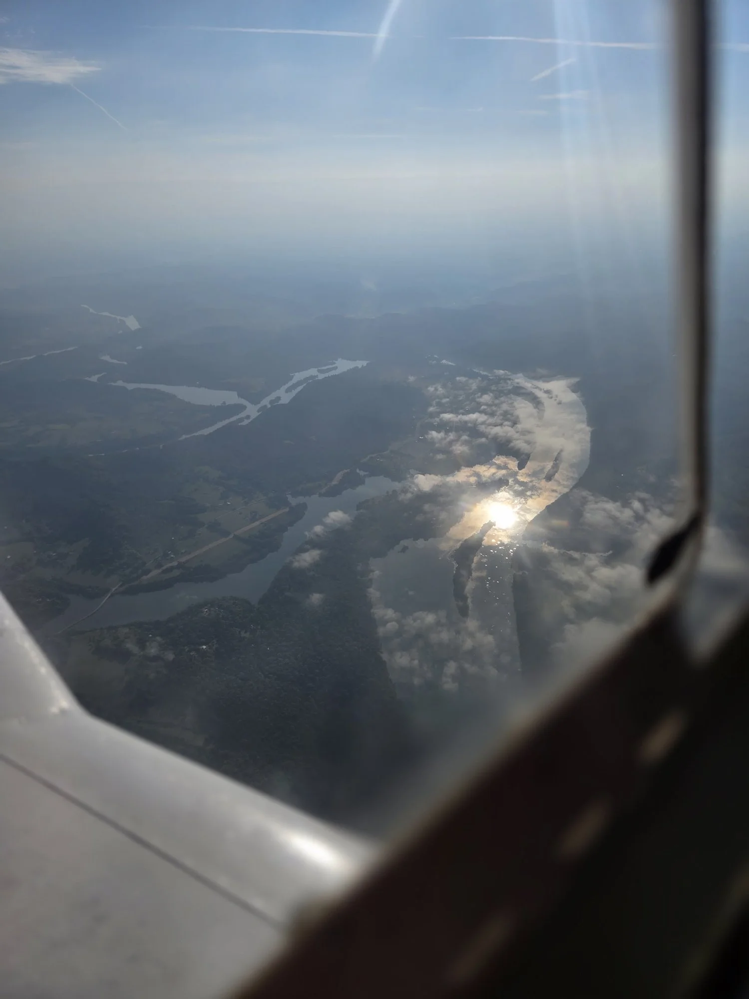 A river winding through wooded ridges, seen from the window of Lucy, a Cherokee 180, on the flight down
