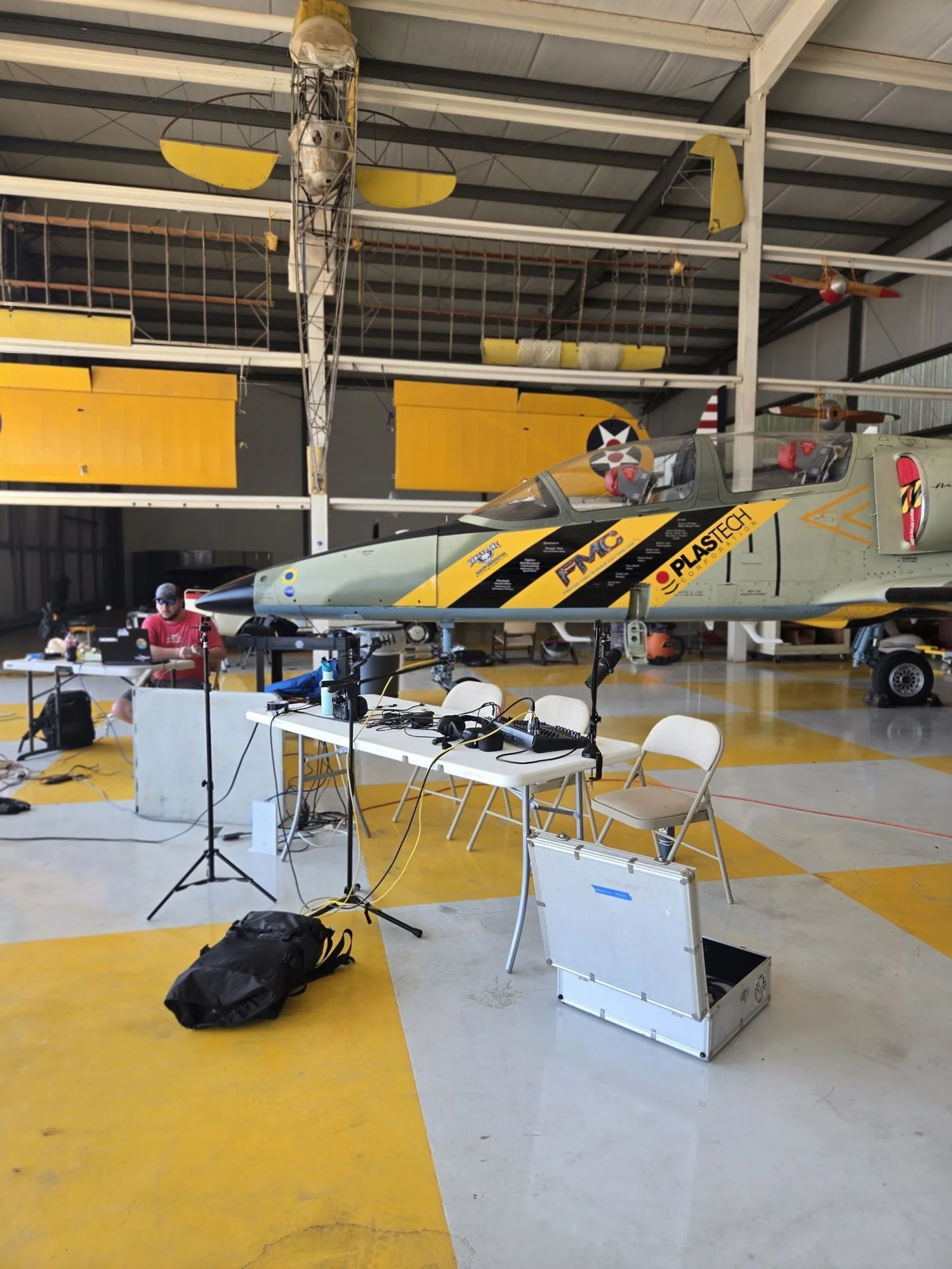 The empty podcast table and microphones set up in the hangar before the live show