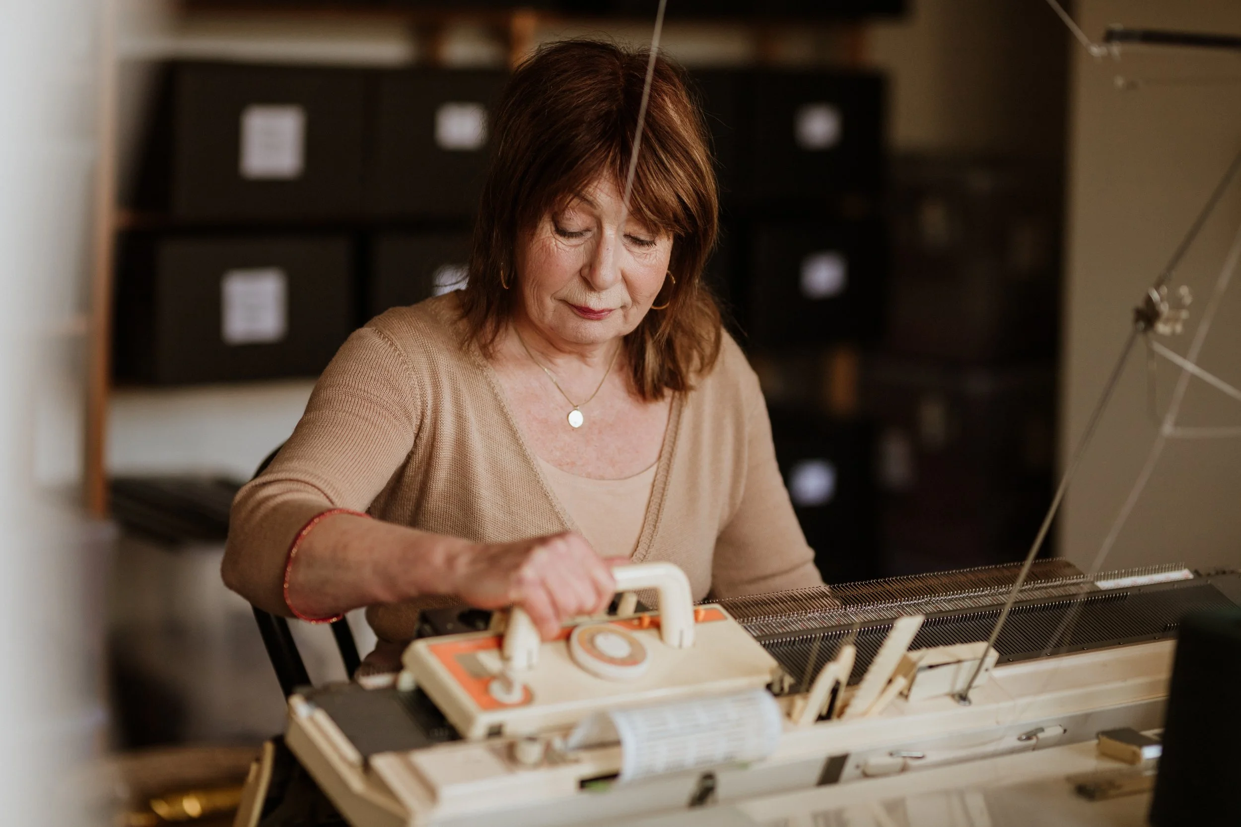 Miriam Lenarts hand-finishing a knitwear sample in the Studio Myr atelier, crafting small-batch designs with care and precision.