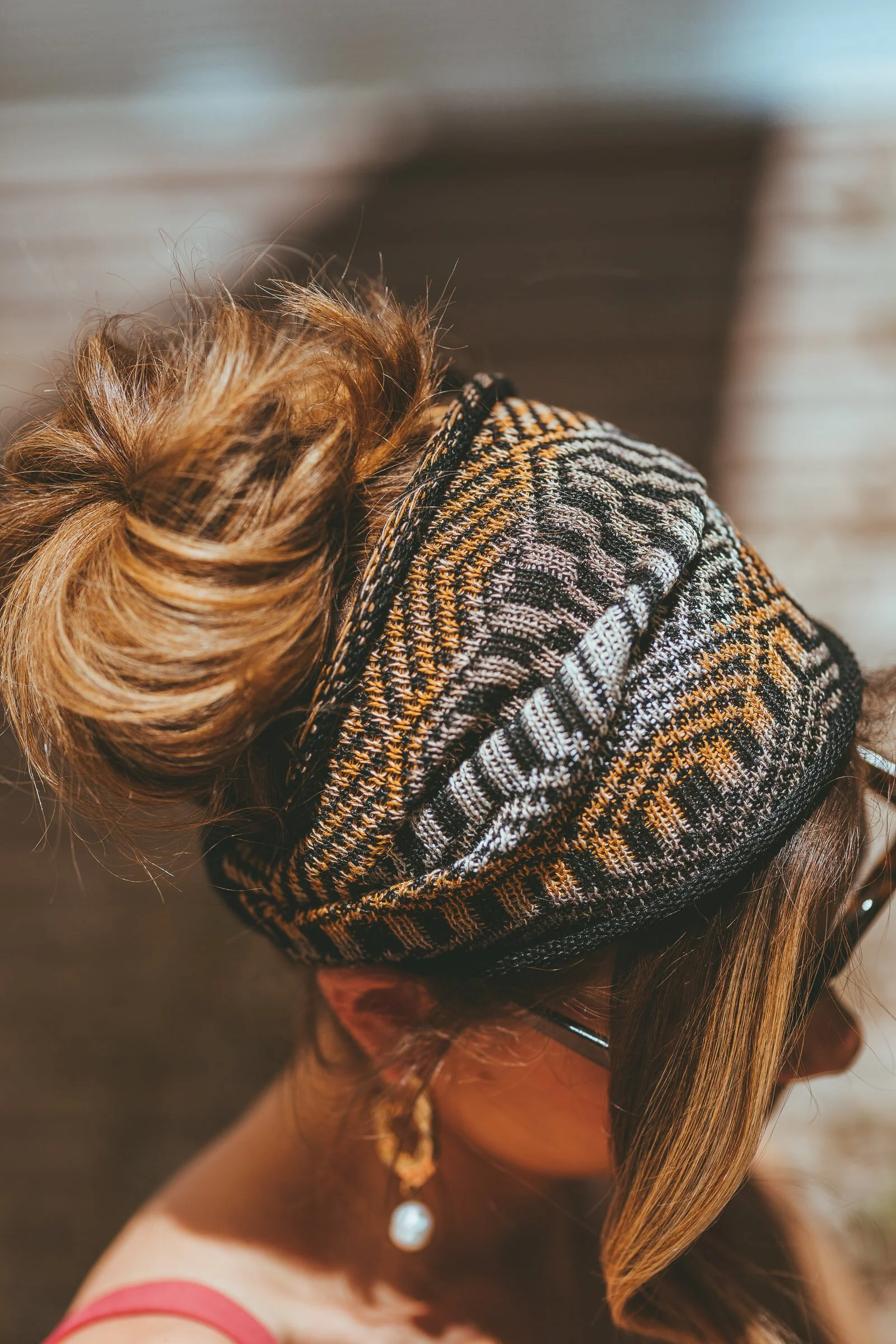 African Nomads Dogon bandana by Studio Myr – close-up of model wearing knitted geometric hairband in earthy tones, luxury artisan headband ethically made in the Netherlands