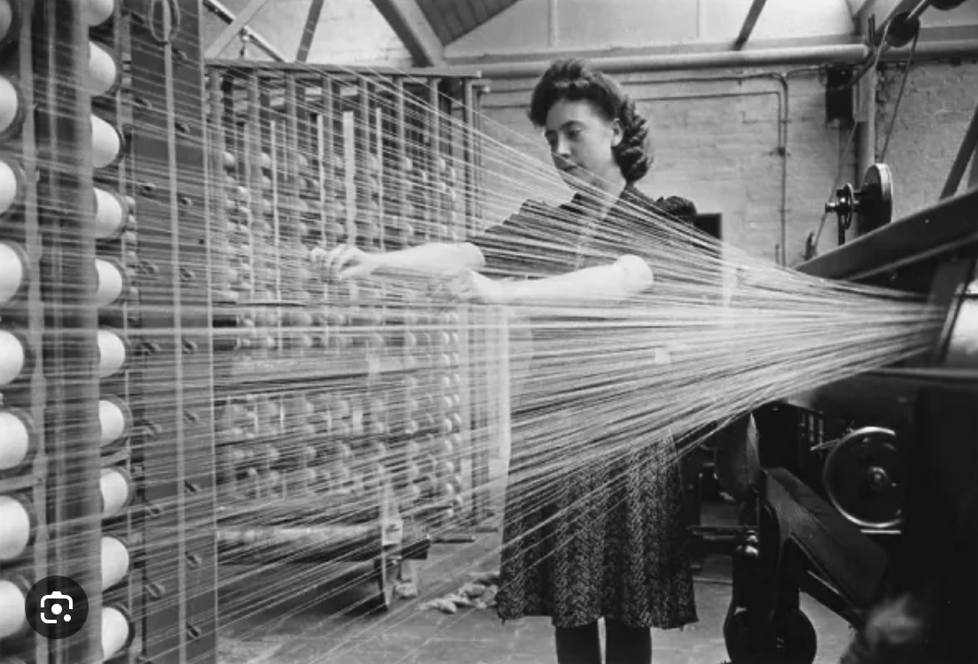 worker operating a mechanised loom producing linen fabric during industrialisation