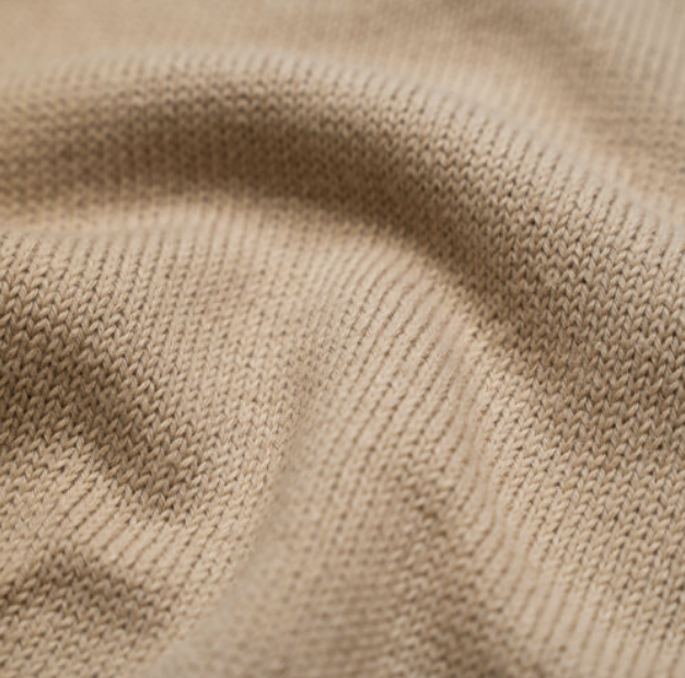 Close-up of soft extra fine Merino wool knit in a warm natural beige tone, showing the refined texture and drape of the fabric used by Studio Myr.