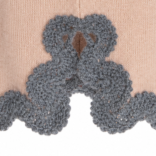 Close-up of the Gabriella BAROQUE skirt's decorative back slit, showcasing intricate Grey Baby Alpaca crochet lace, individually handcrafted and carefully attached to the Beige Merino knit.