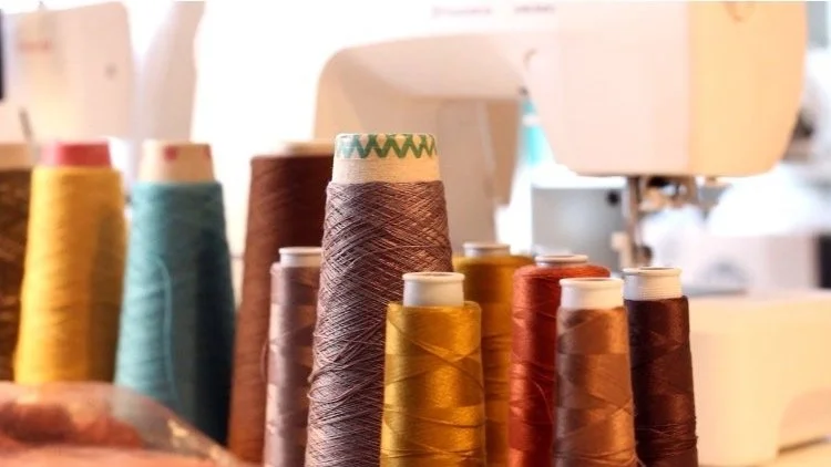 Spools of yarn in natural and rich tones in the Studio Myr atelier, illustrating material selection, color harmony, and the foundations of knitwear craftsmanship