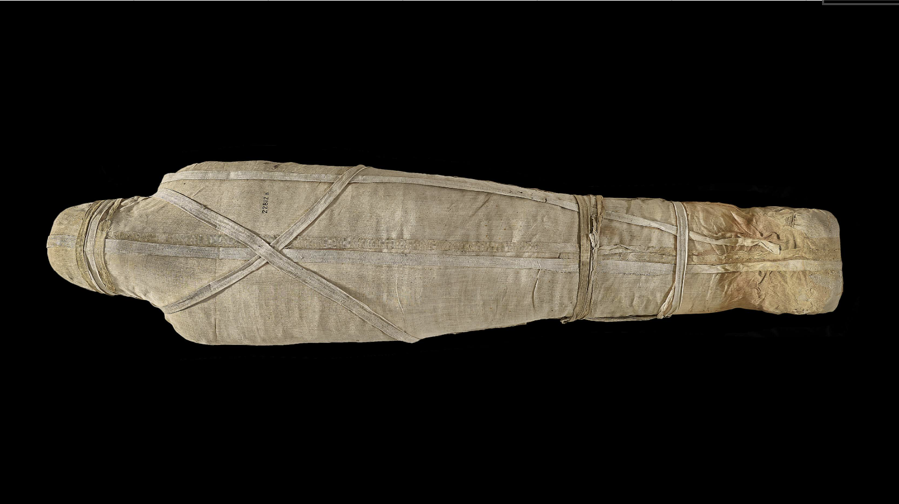 Ancient Egyptian mummy wrapped in linen textiles, showing preserved burial wrappings