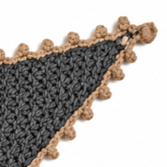 Close-up of the Gabriella triangular scarf showing the textured grey Merino knit, delicate beige Baby Alpaca crochet edging and handcrafted button closure.