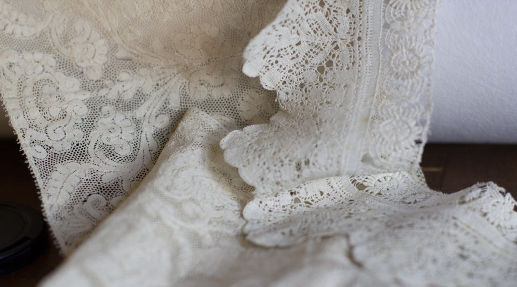 Close-up of fine 17th-century linen lace with delicate floral motifs and soft, transparent structure