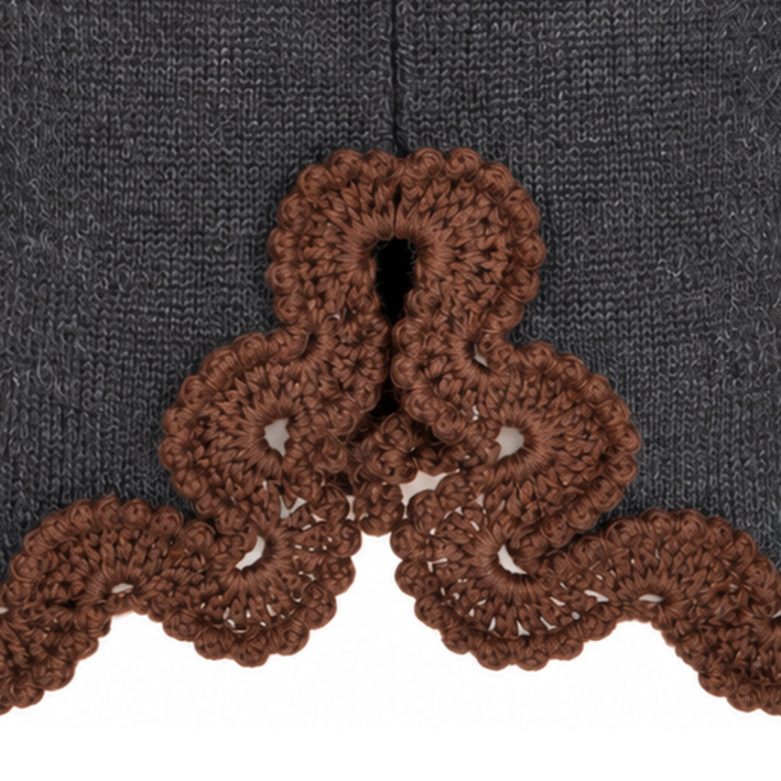 Close-up of the Francisca BAROQUE skirt's decorative back slit, showcasing intricate Chocolate Brown Baby Alpaca crochet lace, individually handcrafted and attached to the Anthracite Grey Merino knit.