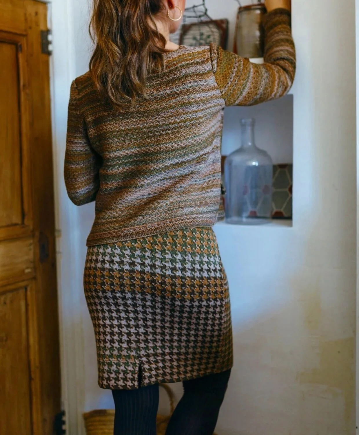 Pied de poule jacquard knit merino blend pencil skirt in shades of green and ocher on model