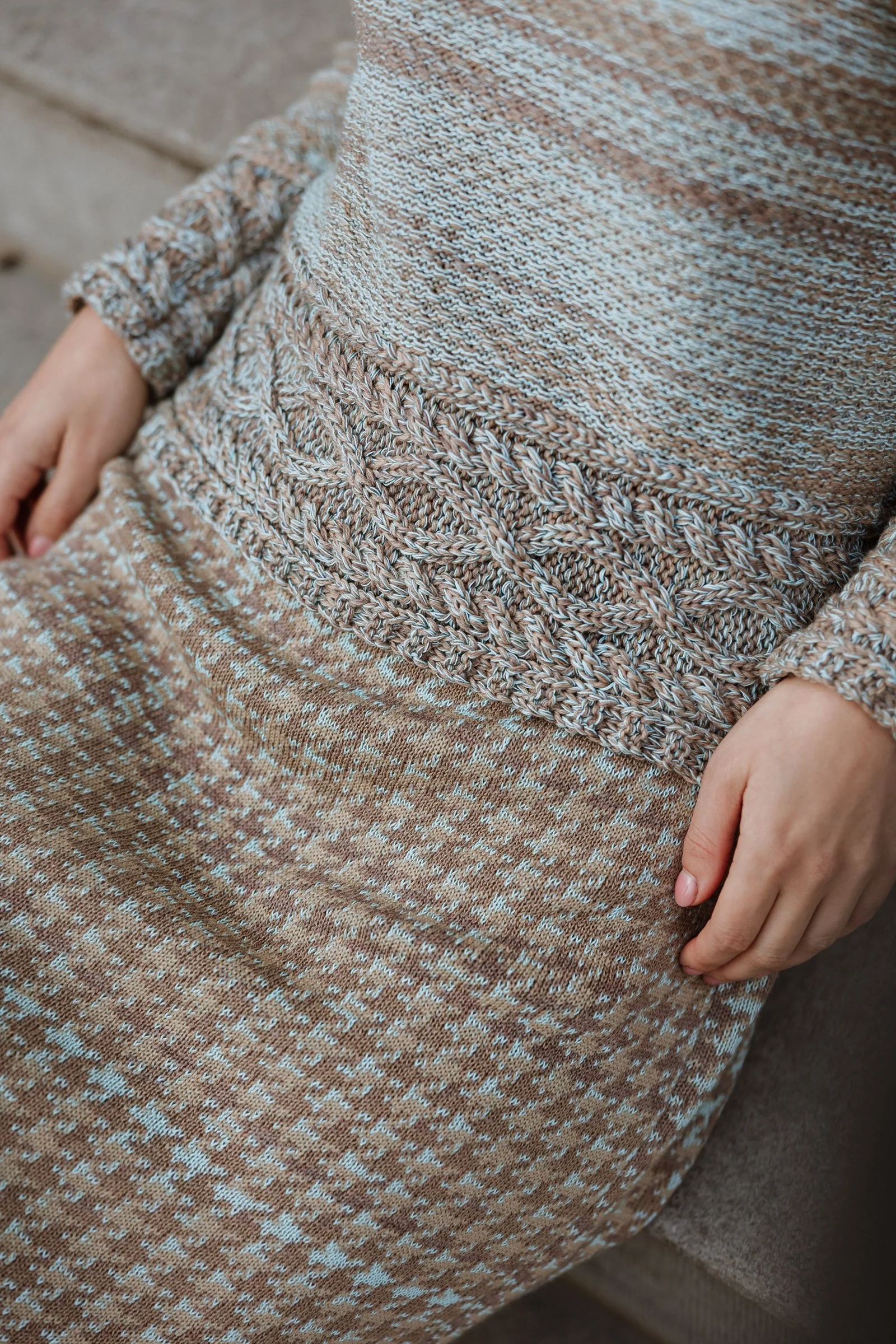 Close-up of a knitted skirt and Aran jumper detail, highlighting the refined texture and structure of the fabric.