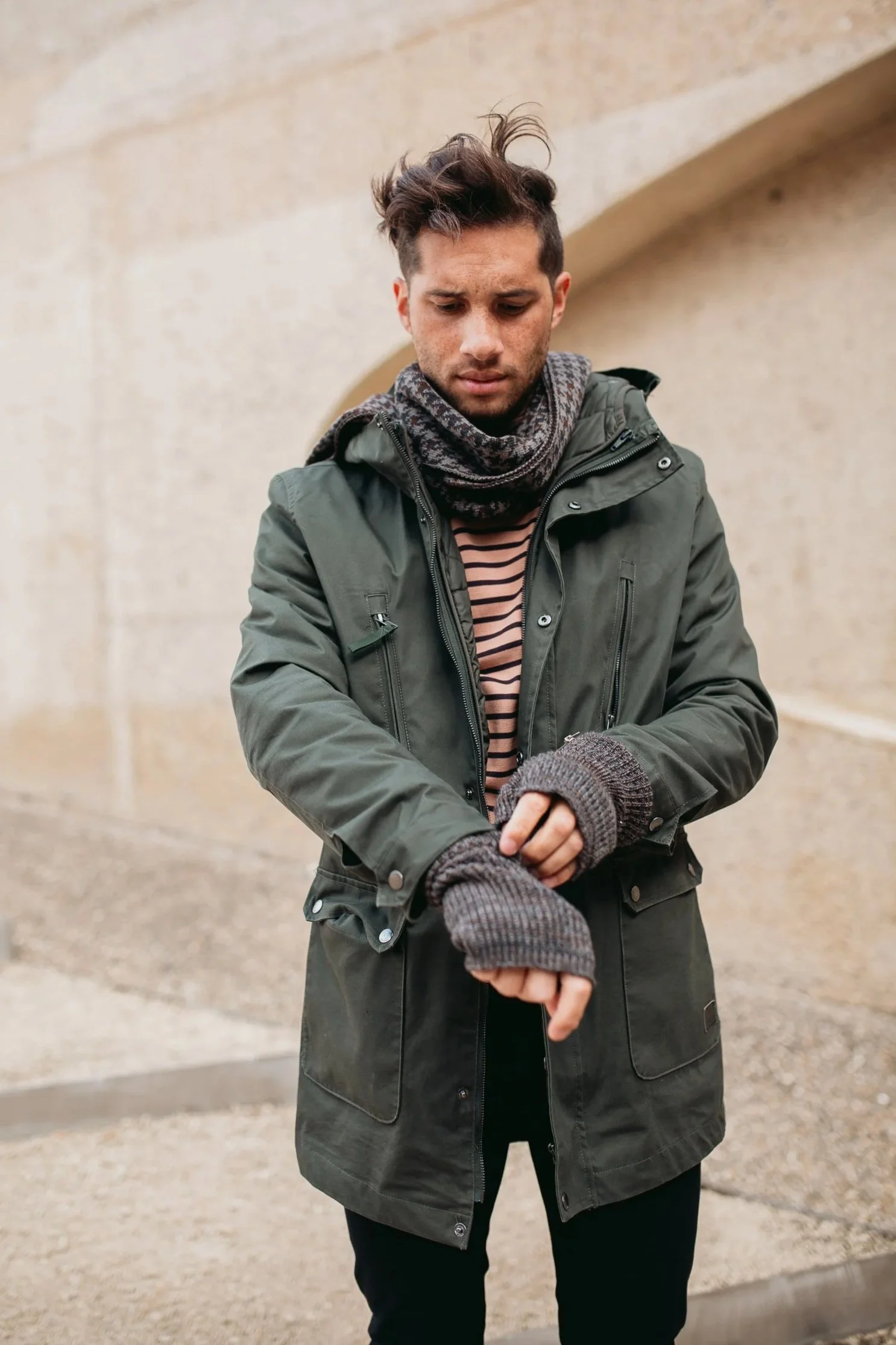 Man wearing Studio Myr gents knit accessories, styled with a merino scarf and fingerless gloves layered under an outer jacket