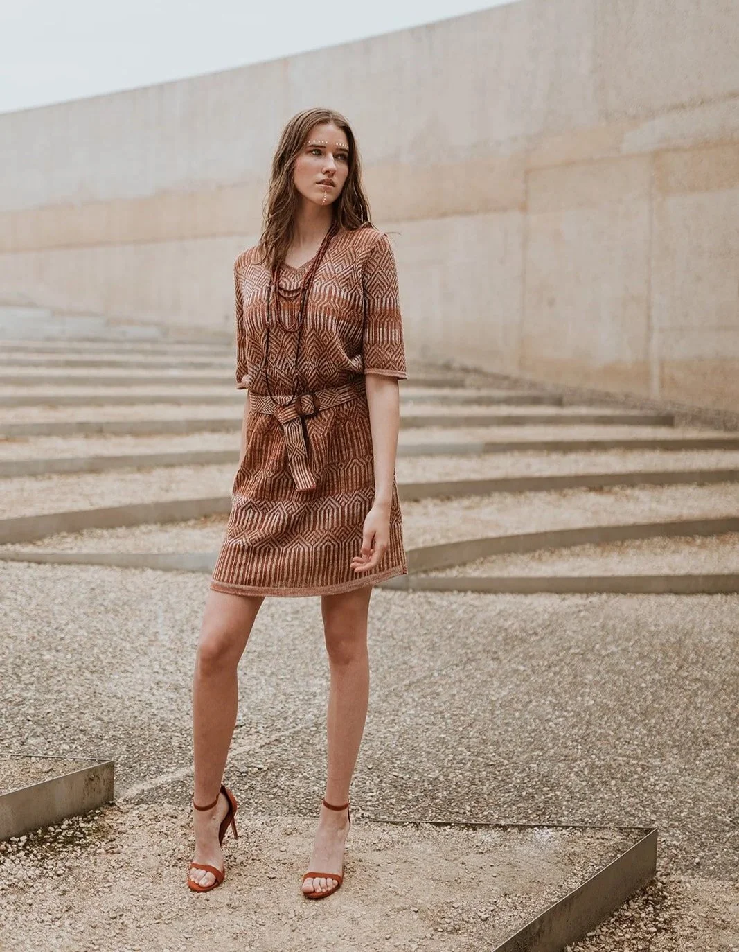 Graphic jacquard knitted short sleeve dress with matching belt in linen blend of rust brown and neutrals on model