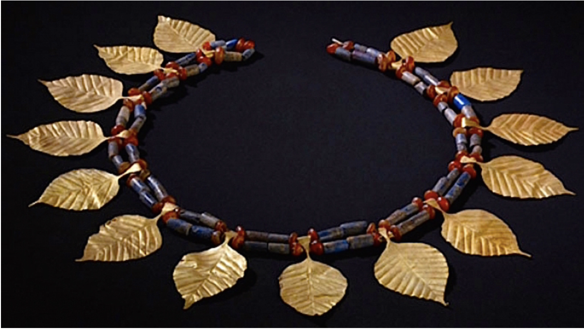 Ancient Mesopotamian gold leaf headpiece with intricate beads, an early example of ornamental hair adornment in women’s fashion.