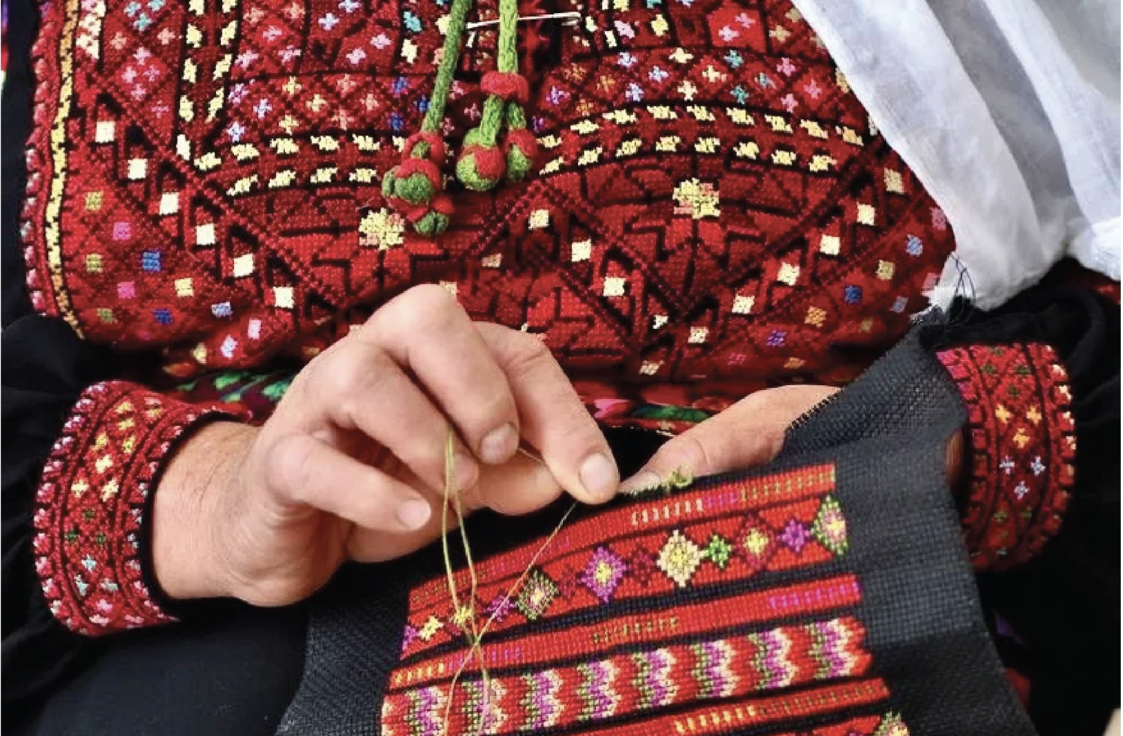 Hands embroidering Palestinian Tatreez, expressing generational knowledge, identity, and the continuity of textile craft