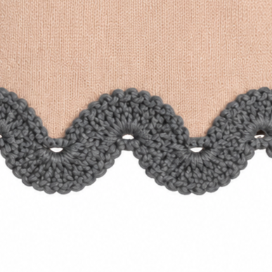 Detail of the Gabriella jumper hem featuring dark grey hand-crocheted Baby Alpaca lace in a decorative scalloped pattern against beige Extra Fine Merino wool.