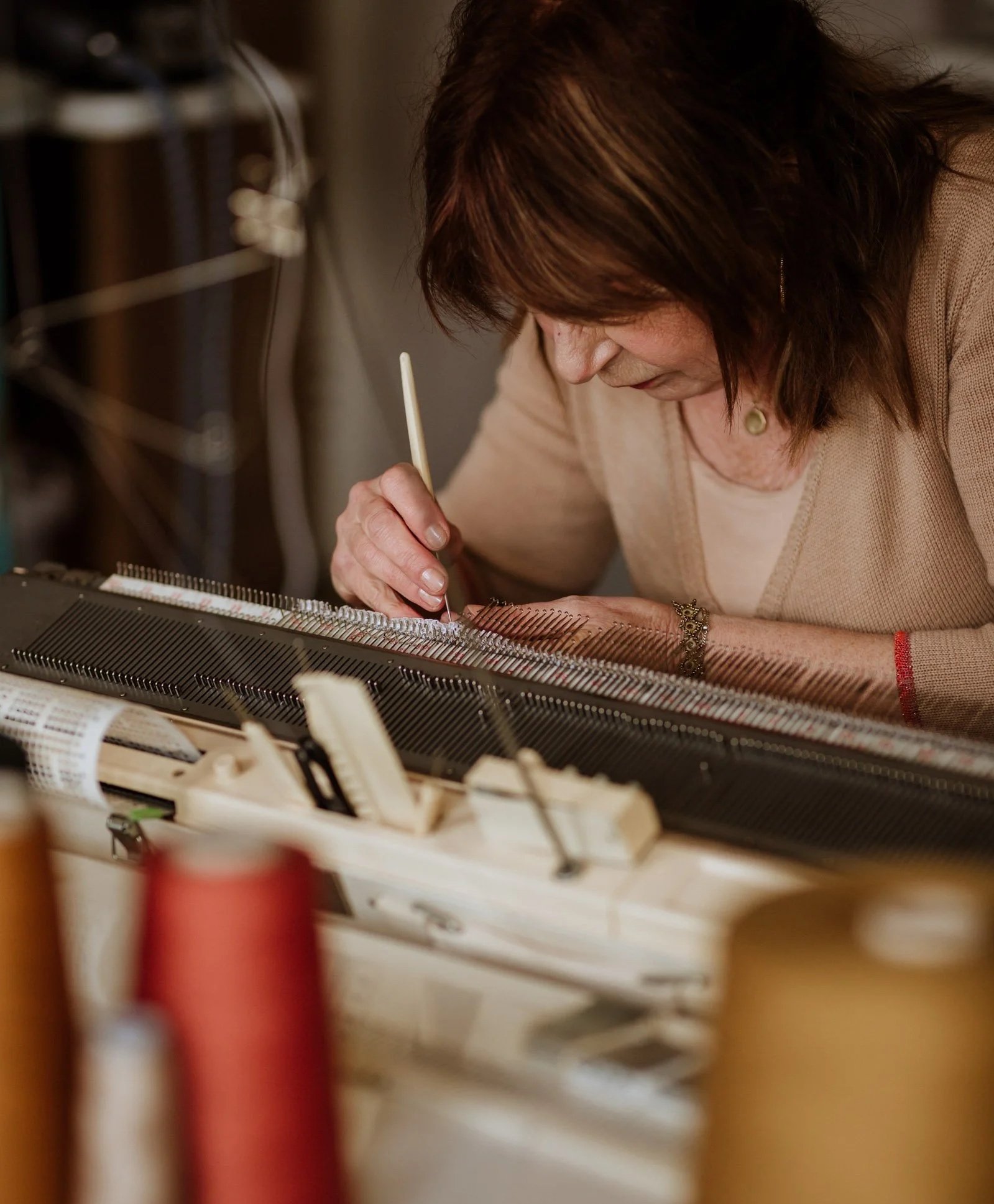 Designer Miriam Lenarts working at het knitting machine in het studio