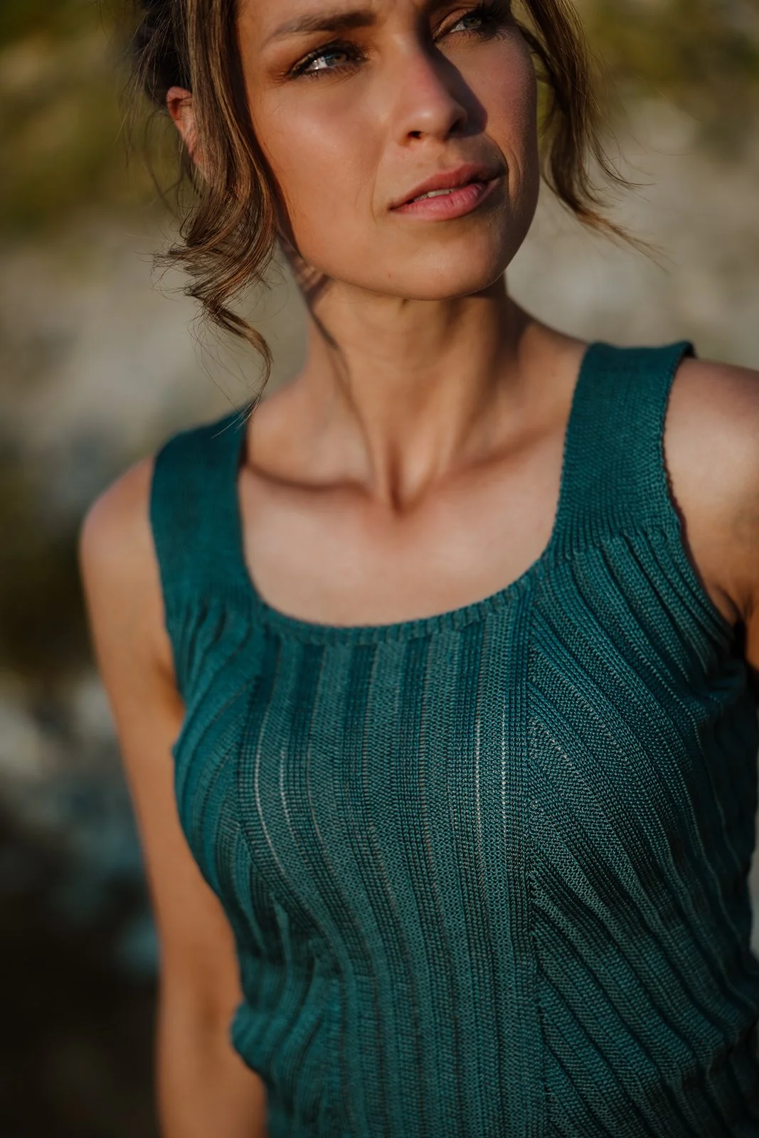 A close-up portrait of the teal rib-knit top Florentina, revealing the refined structure and subtle sheen of the fabric. The deep, saturated colour recalls the Renaissance blue pigments, creating a modern yet classical elegance.