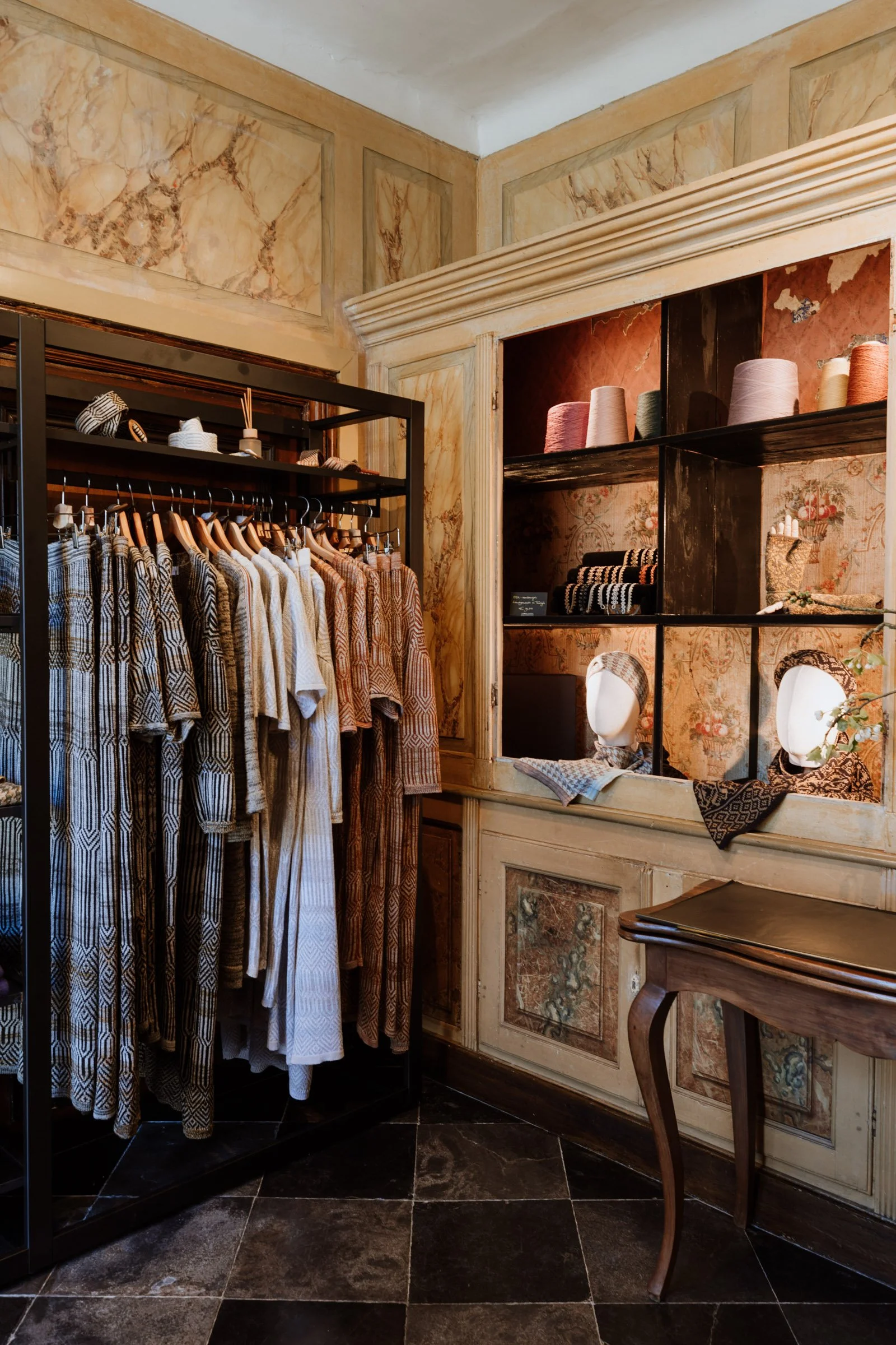 Interior of the Studio Myr boutique, displaying knitwear garments, yarn cones, and accessories in a calm, curated setting