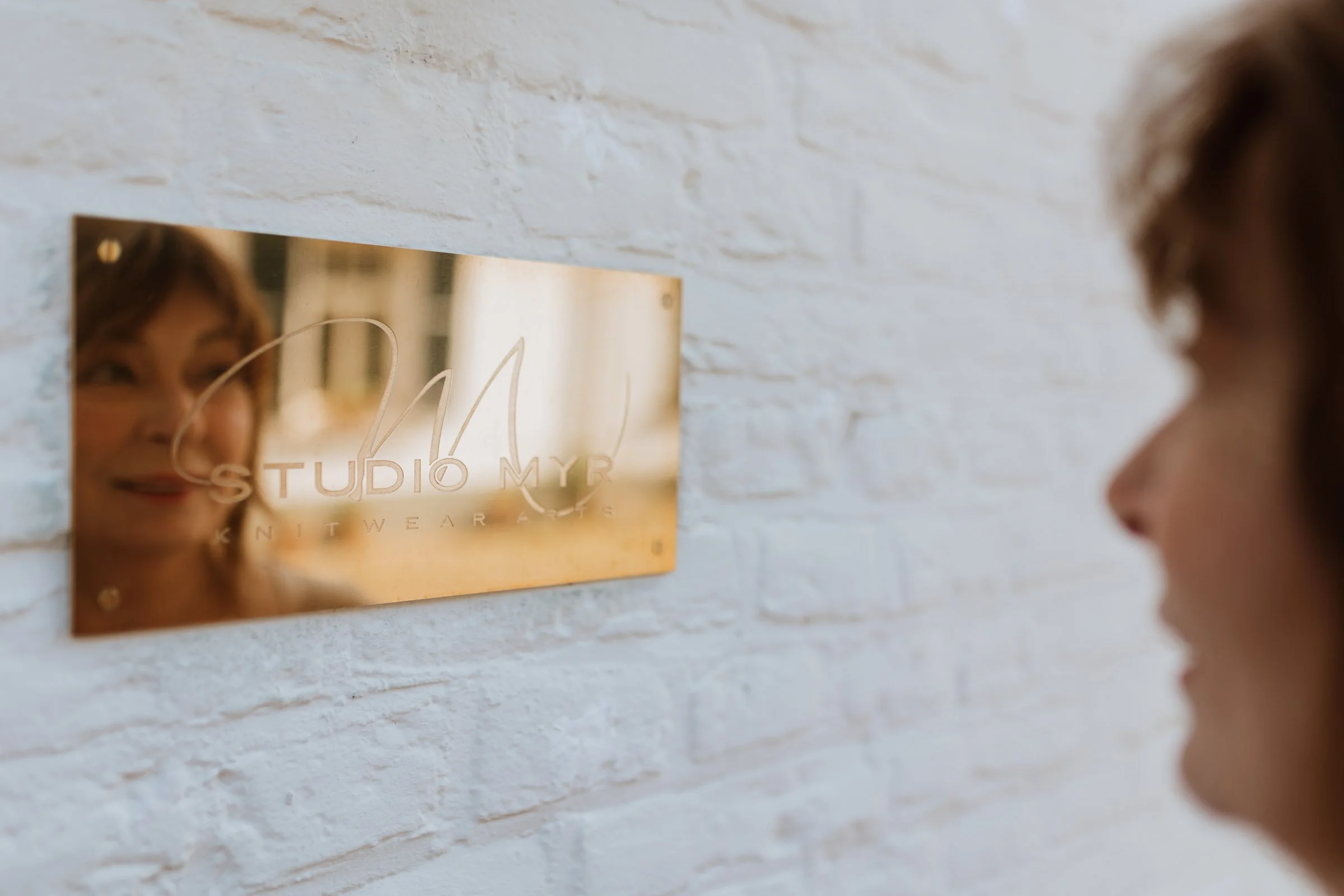 Reflexion of the face of Miriam Lenarts in the nameplate of Studio Myr