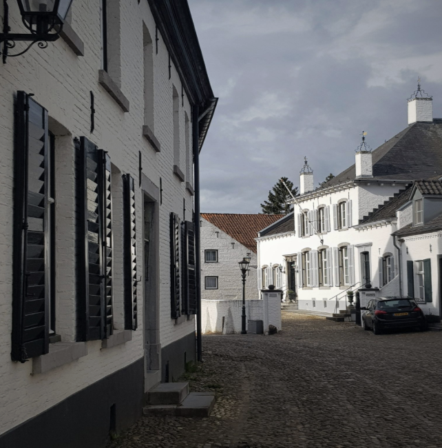 View from Studio Myr towards Huize De Kraek, a former canoness’s residence on a cobbled street in historic Thorn, the Netherlands.