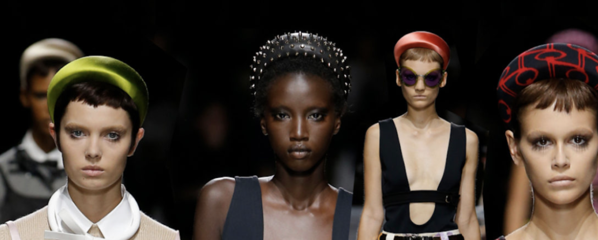Runway models wearing bold sculptural headbands at Prada Spring/Summer 2019 — oversized shapes, velvet textures and statement colours highlighting the resurgence of luxury hair accessories.