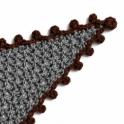 Close-up of the Francisca triangular scarf showing the textured charcoal grey Merino knit, delicate chocolate brown Baby Alpaca crochet edging and handcrafted button closure.