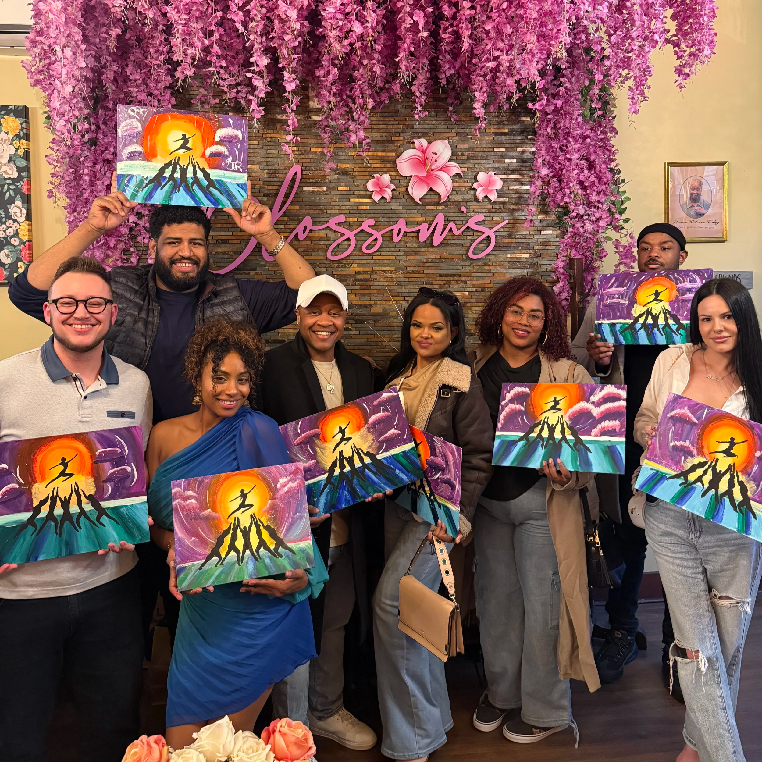 Guests holding their finished paintings after a ColorsintheDark creative event at Blossoms Restaurant in NYC
